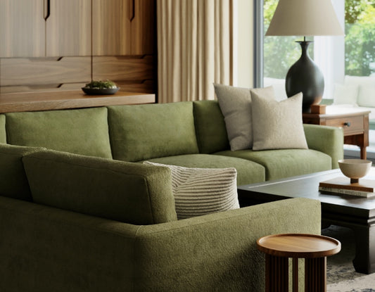 Modern living room with olive green sectional sofa, white pillows, wooden accents, and contemporary black lamp