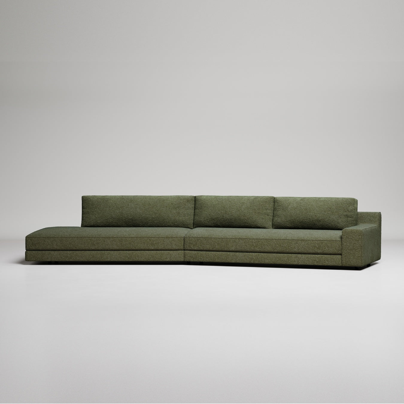 Long modern olive green sectional sofa with clean lines on white background, minimalist design