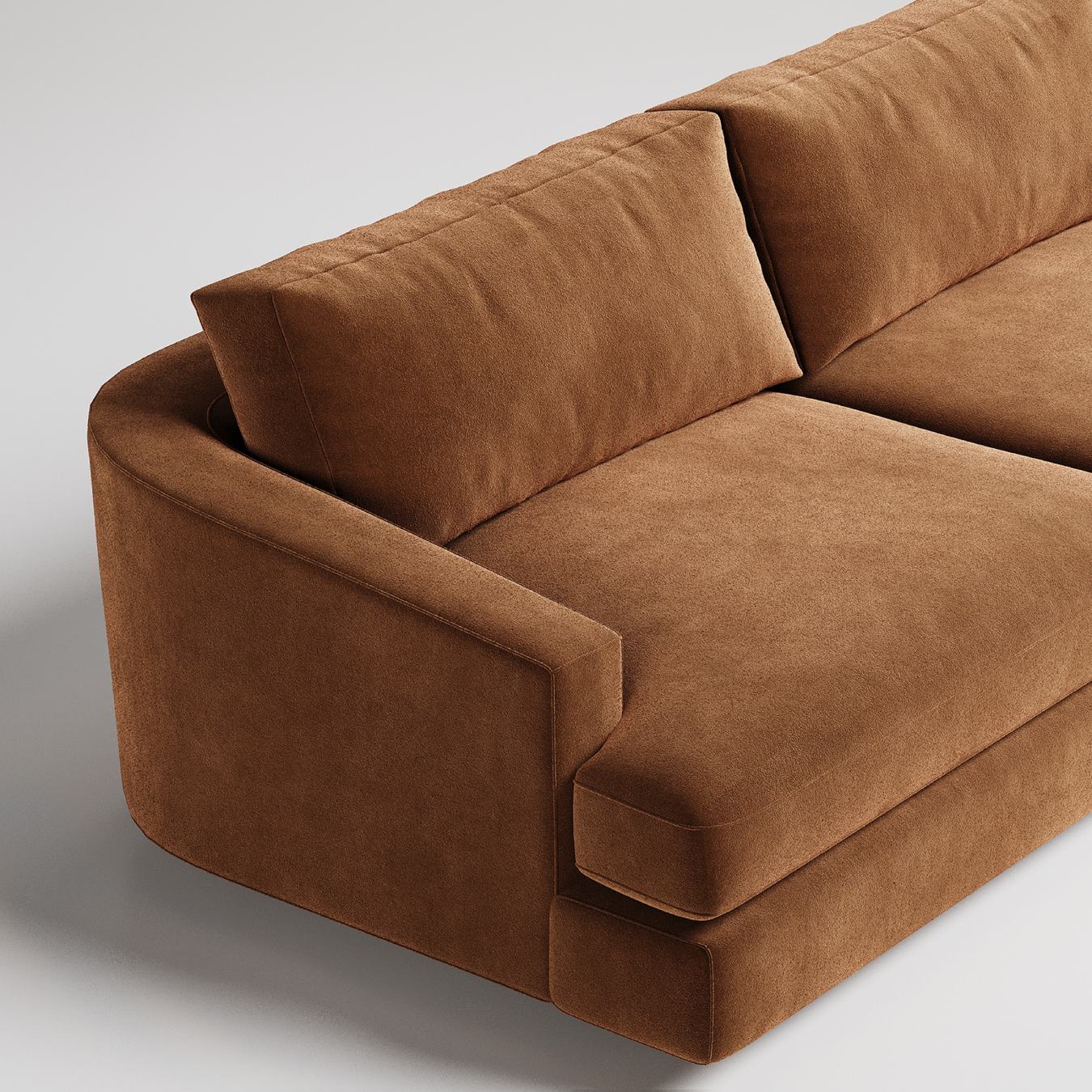 Closeup of modern brown velvet sofa with clean lines and plush cushions against neutral background
