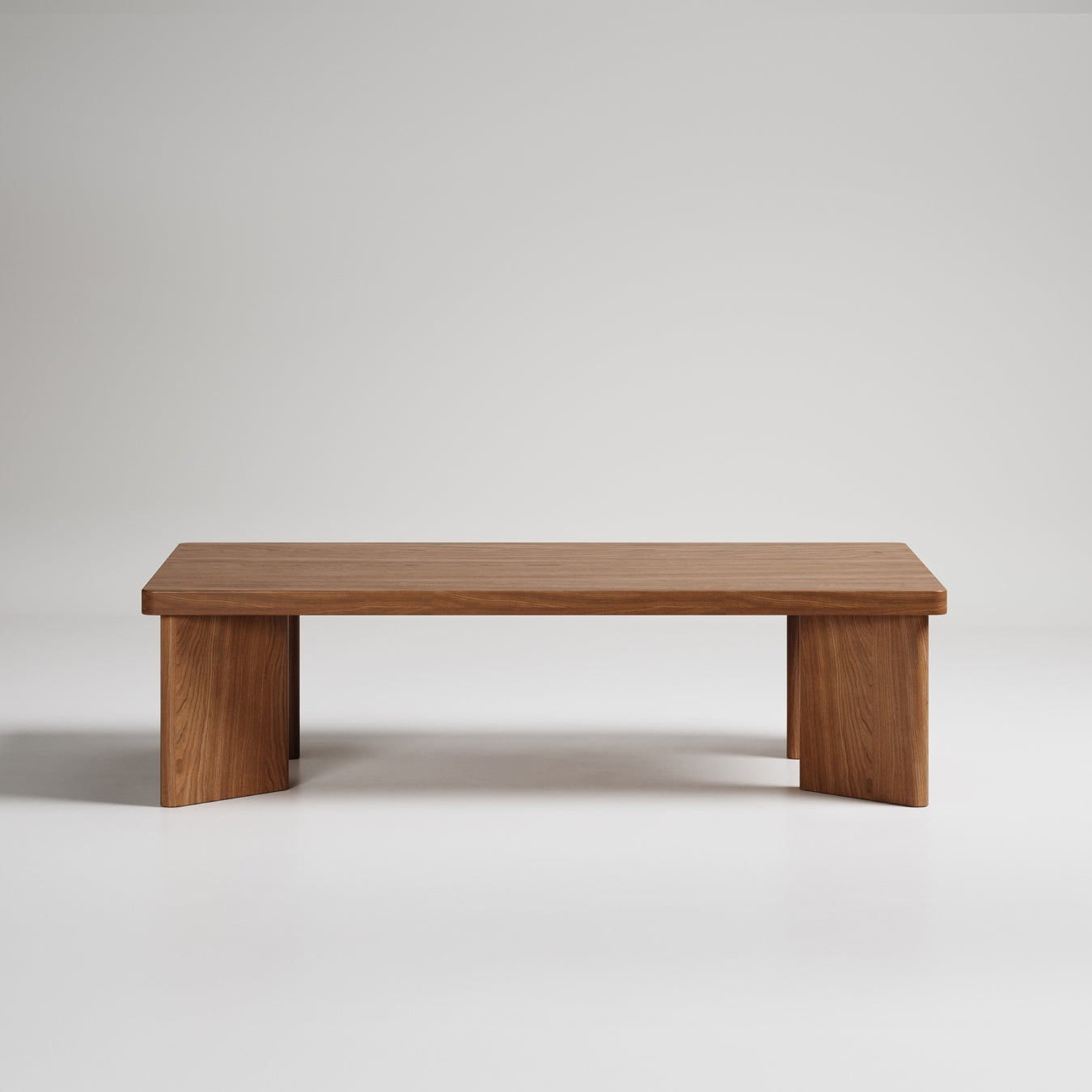 Modern minimalist wooden coffee table with thick rectangular top and solid panel legs against white background