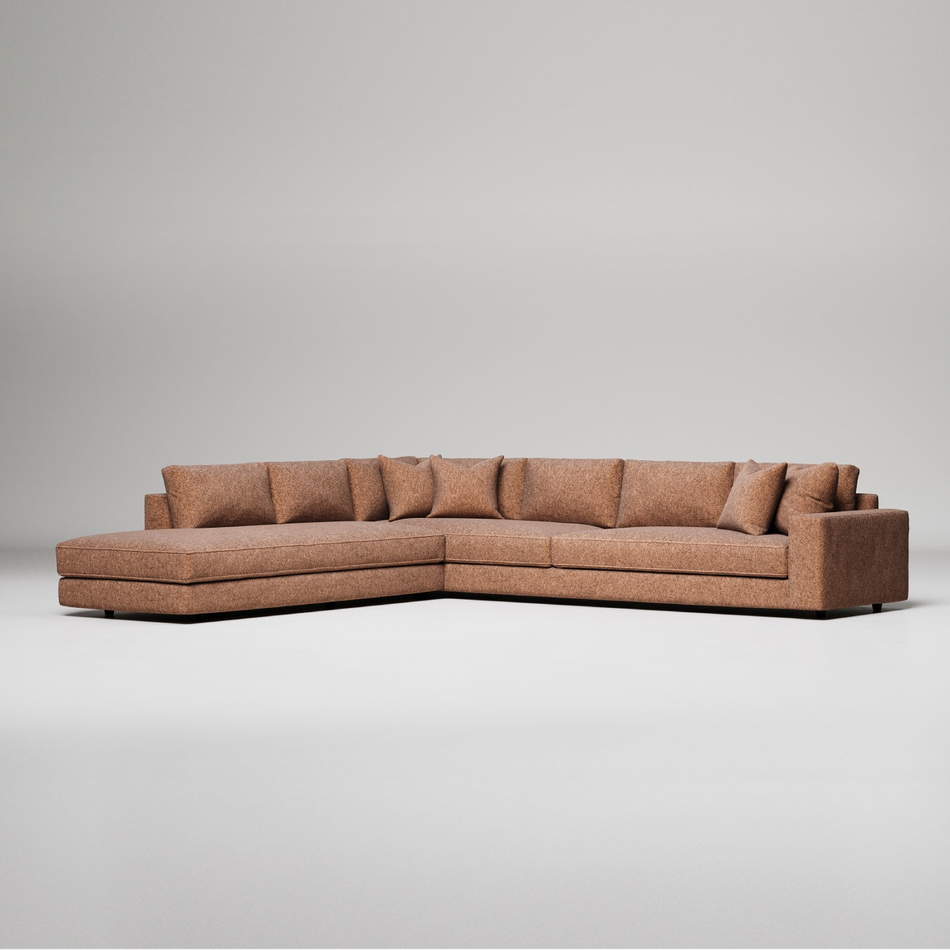 Modern L-shaped sectional sofa in brown textured fabric with chaise lounge and decorative pillows against gray background