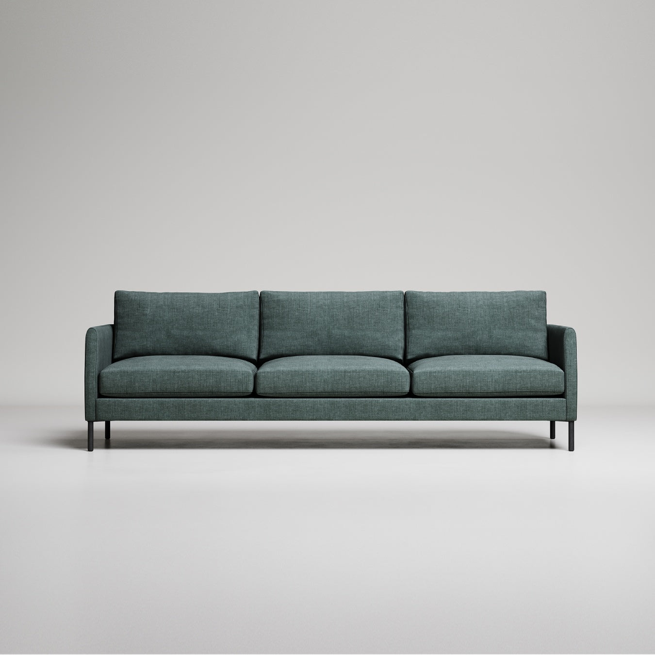 Modern green three-seater sofa with black metal legs on light gray background, studio setting