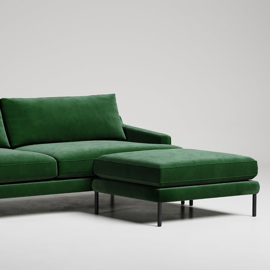 Modern green velvet sectional sofa with chaise ottoman on black metal legs against white background
