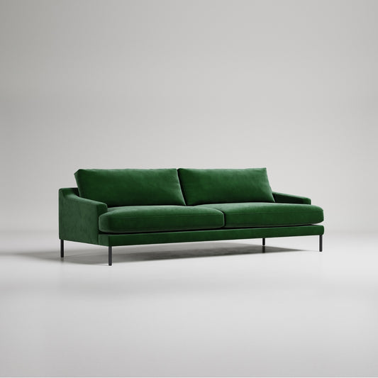 Modern emerald green velvet sofa with black metal legs on white background, studio product photography