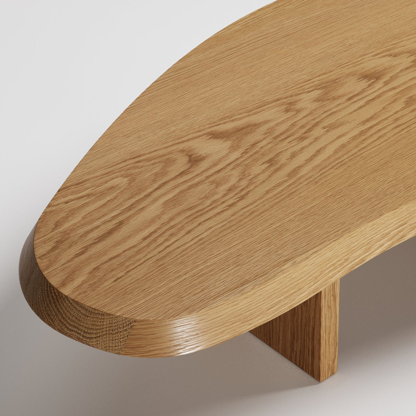 Modern oval oak coffee table with curved edges and minimalist wooden base, close-up detail shot
