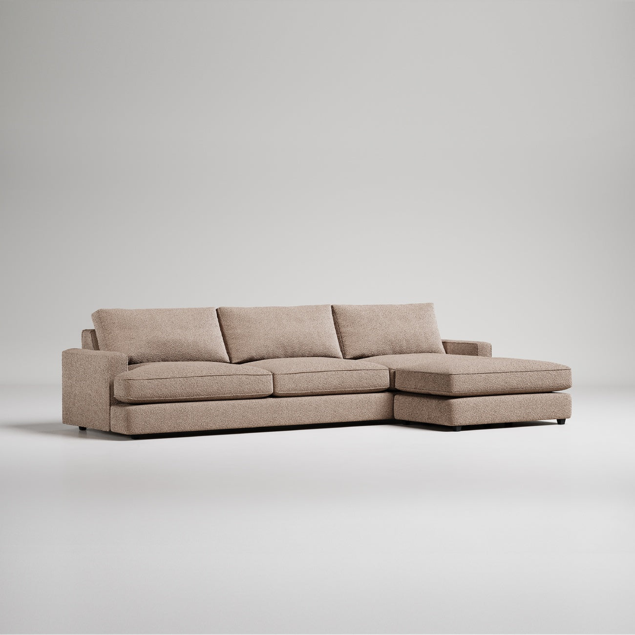 Modern L-shaped sectional sofa in beige textured fabric with chaise lounge against white background