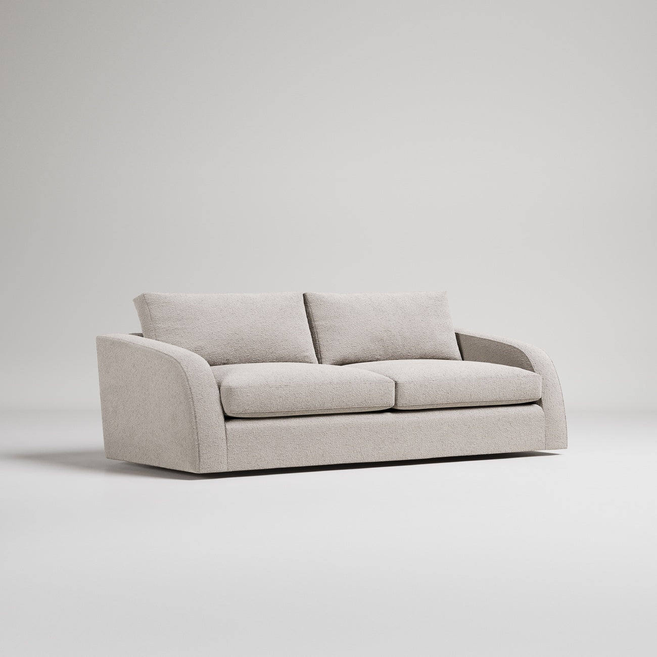 Modern minimalist beige sofa with curved arms and plush cushions on white background, studio shot
