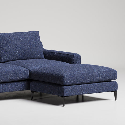 Modern navy blue sectional sofa with chaise lounge on black metal legs against white background