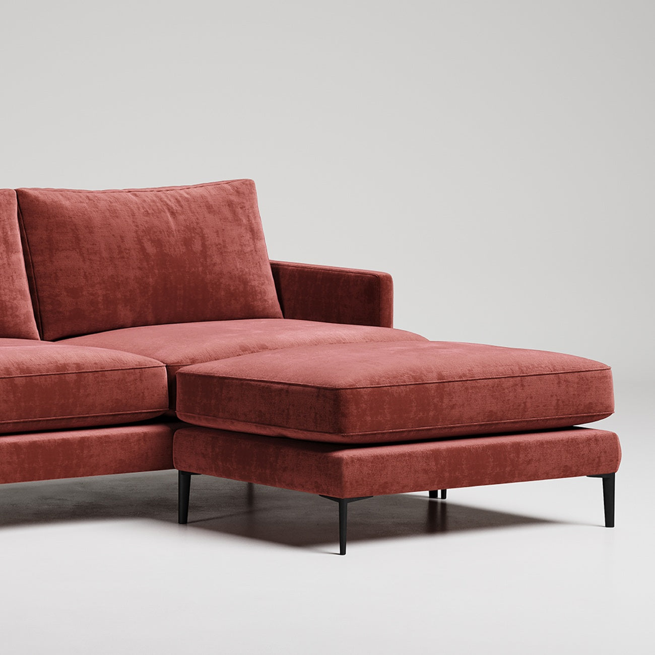 Modern terracotta velvet sectional sofa ottoman with black metal legs against white background