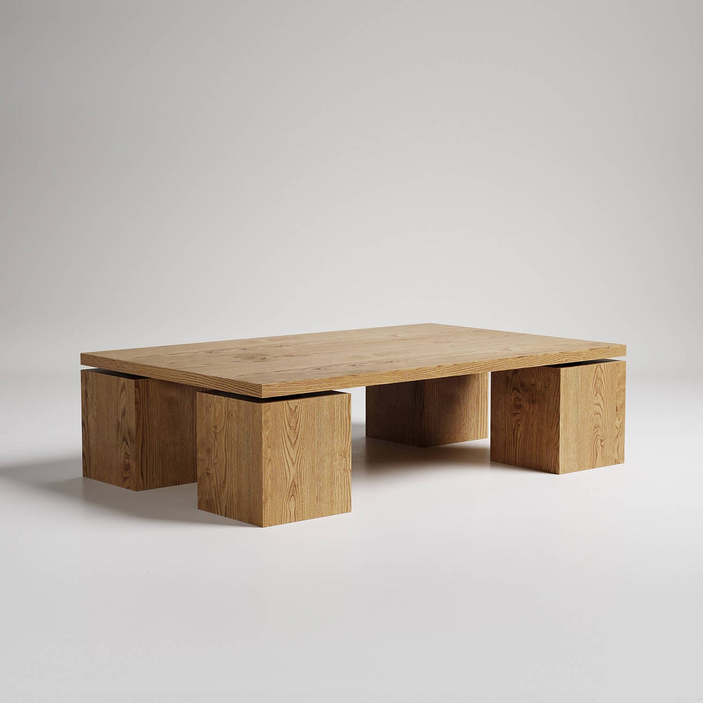Modern minimalist coffee table with three solid oak cube bases supporting rectangular wooden top against white background