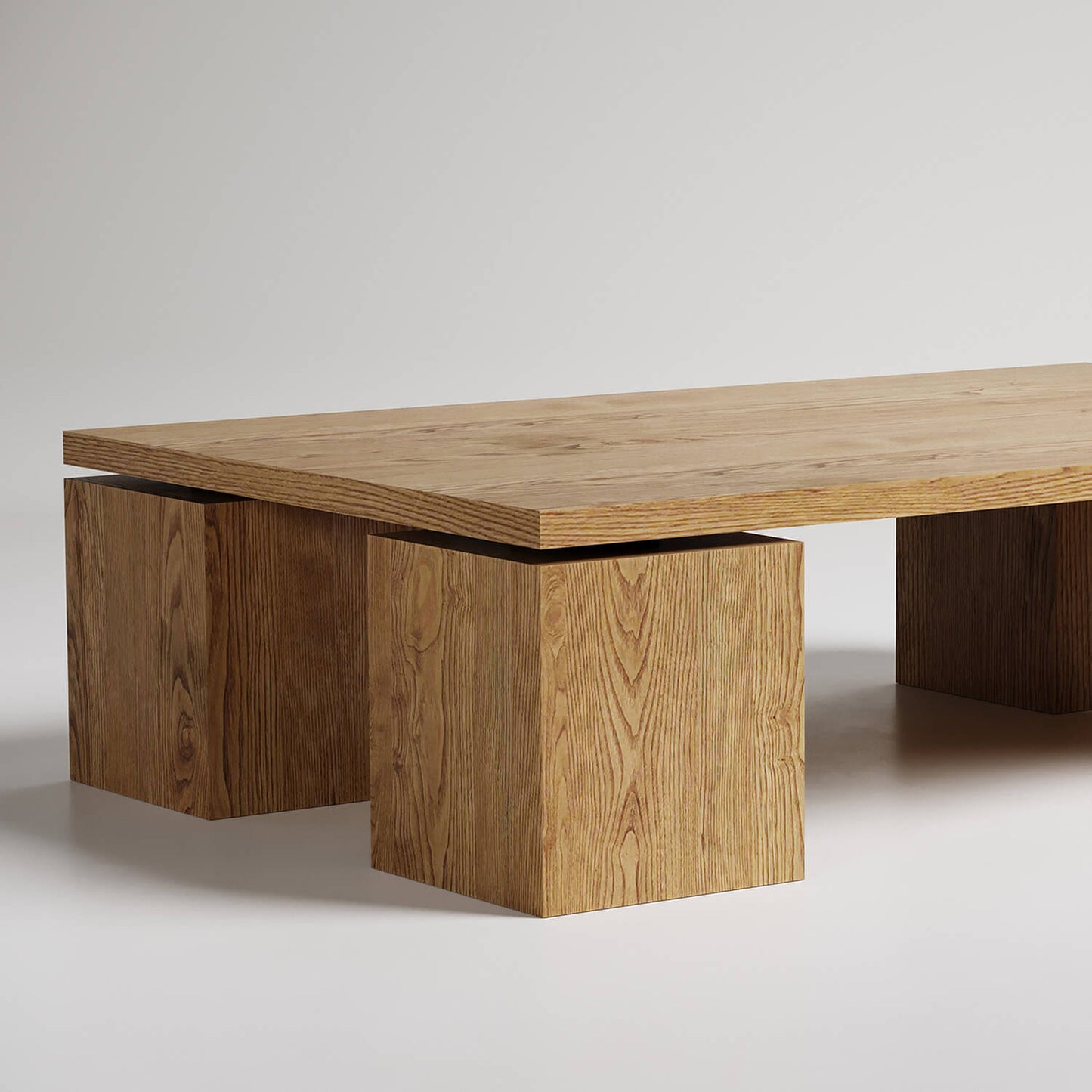 Modern minimalist coffee table with thick wooden top and two geometric cube bases, natural oak finish