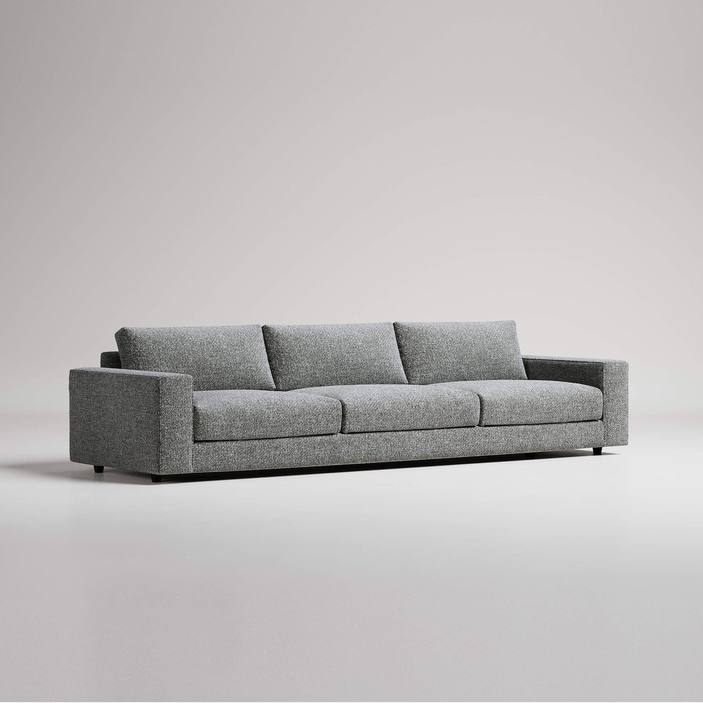 Modern grey three-seater sofa with clean lines against white background, studio product photography