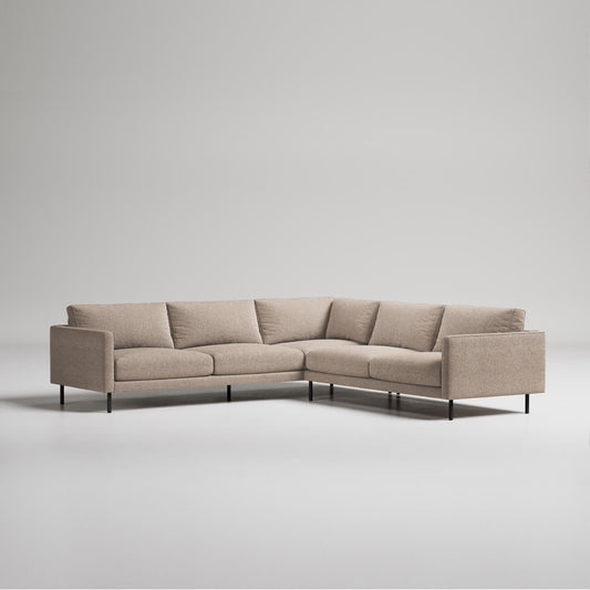 Modern L-shaped beige sectional sofa with slim black metal legs on white background, minimalist contemporary design