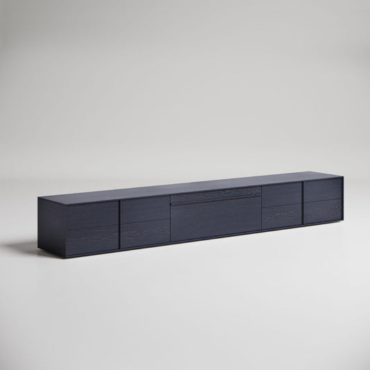 Modern low-profile dark wood media console with horizontal drawers against white background