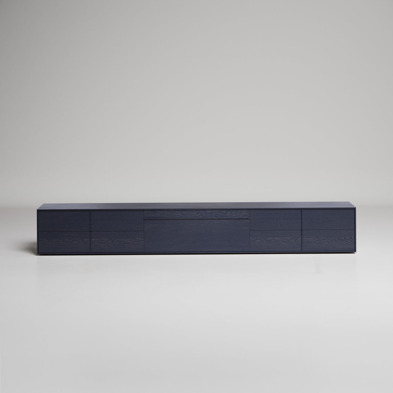 Modern low-profile black wooden media console with minimalist design against white background