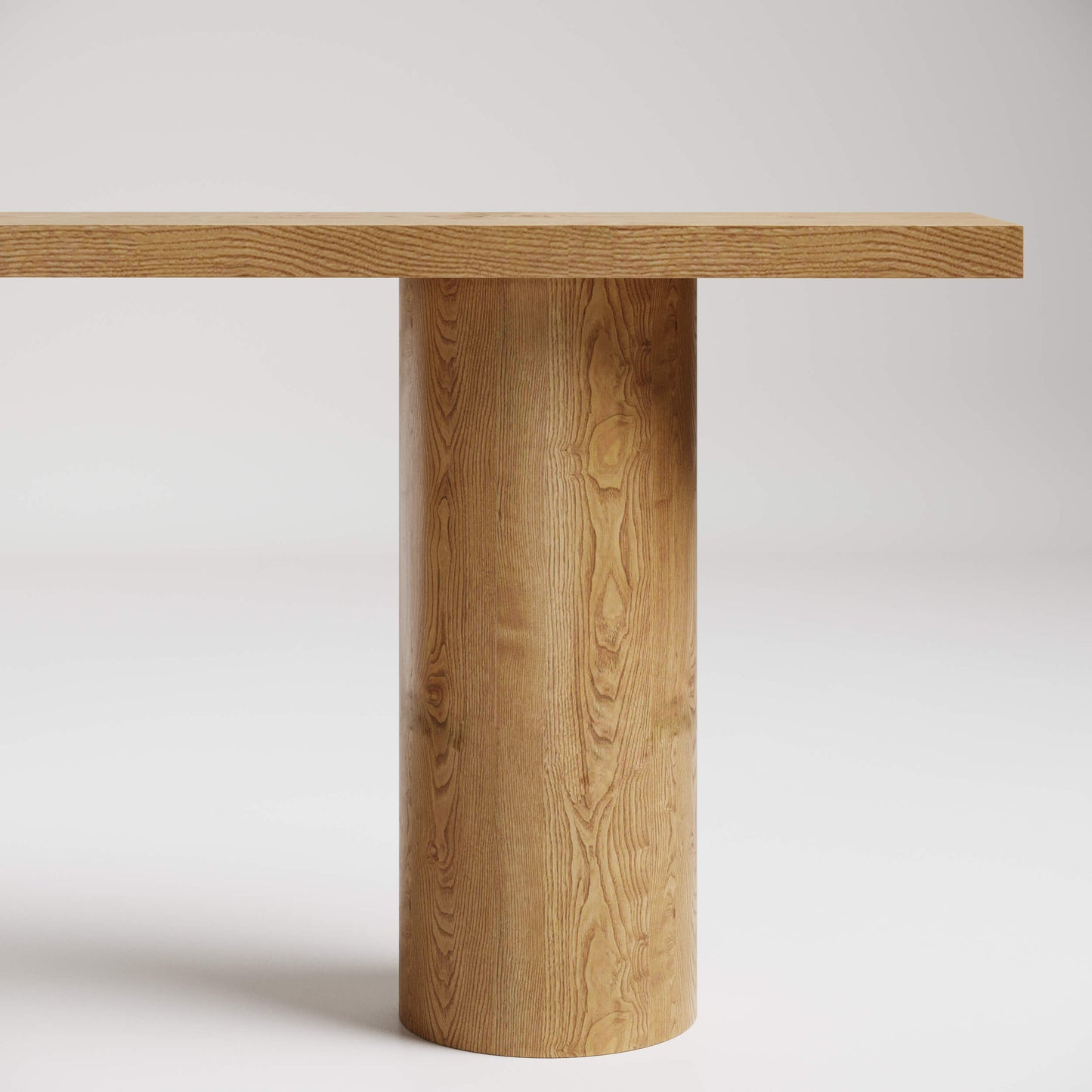 Minimalist wooden dining table with cylindrical pedestal base and rectangular top, showcasing natural grain pattern