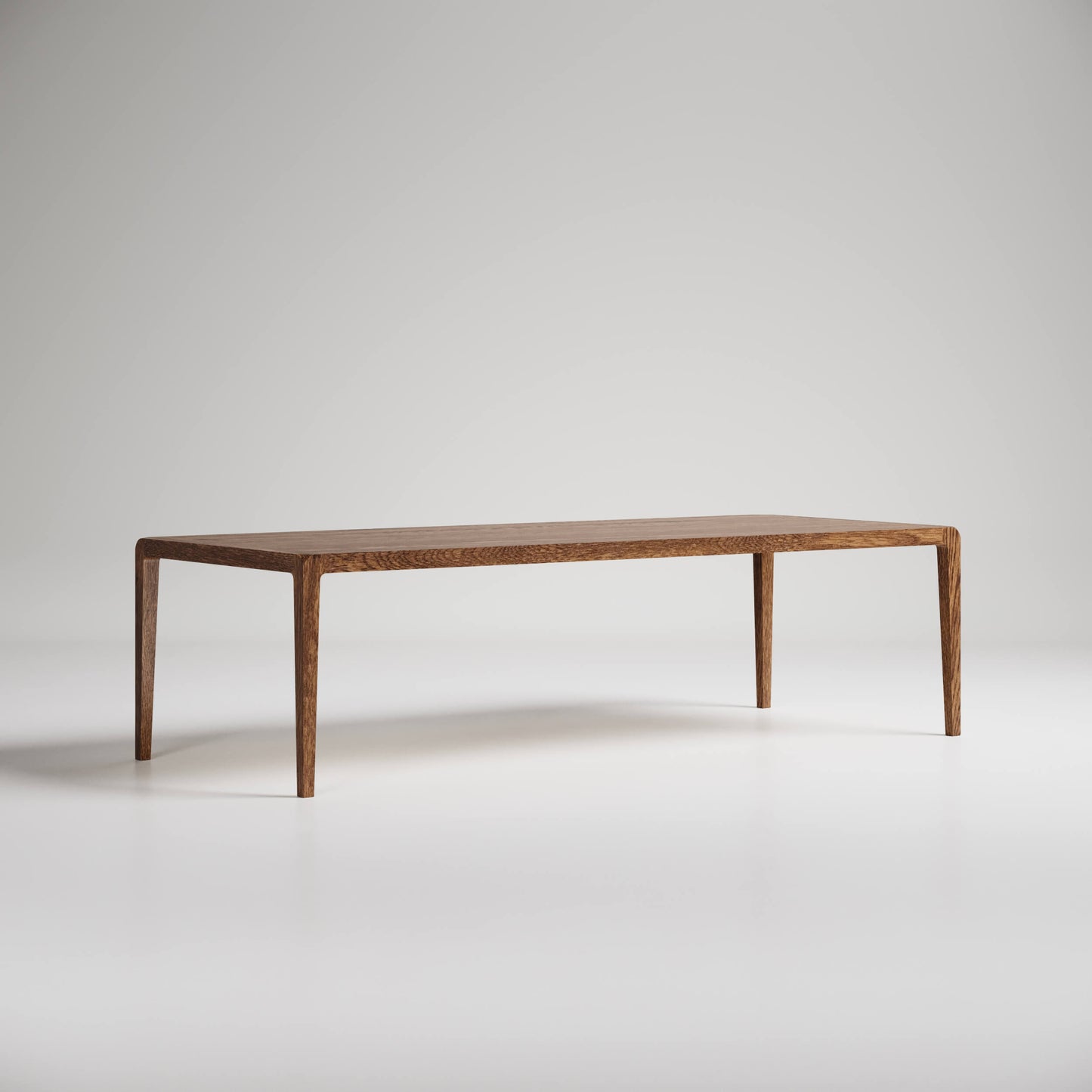 Modern minimalist rectangular wooden coffee table with slim tapered legs on white background