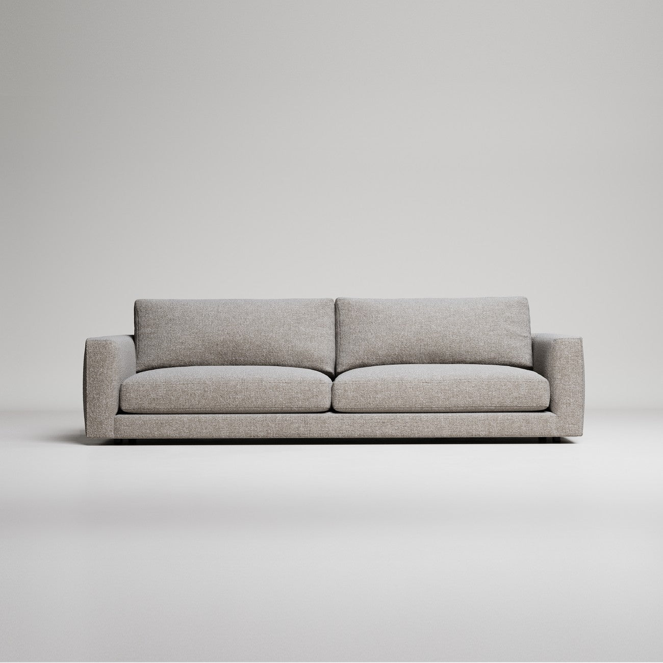 Modern grey fabric sofa with clean lines against white background, minimalist studio product photography