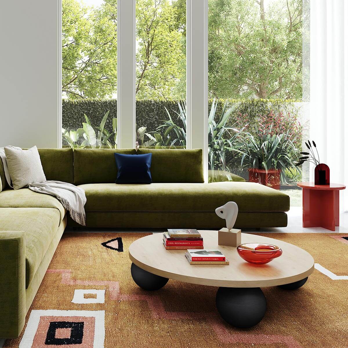 Modern living room with olive velvet sectional, unique round coffee table, floor-to-ceiling windows and garden views