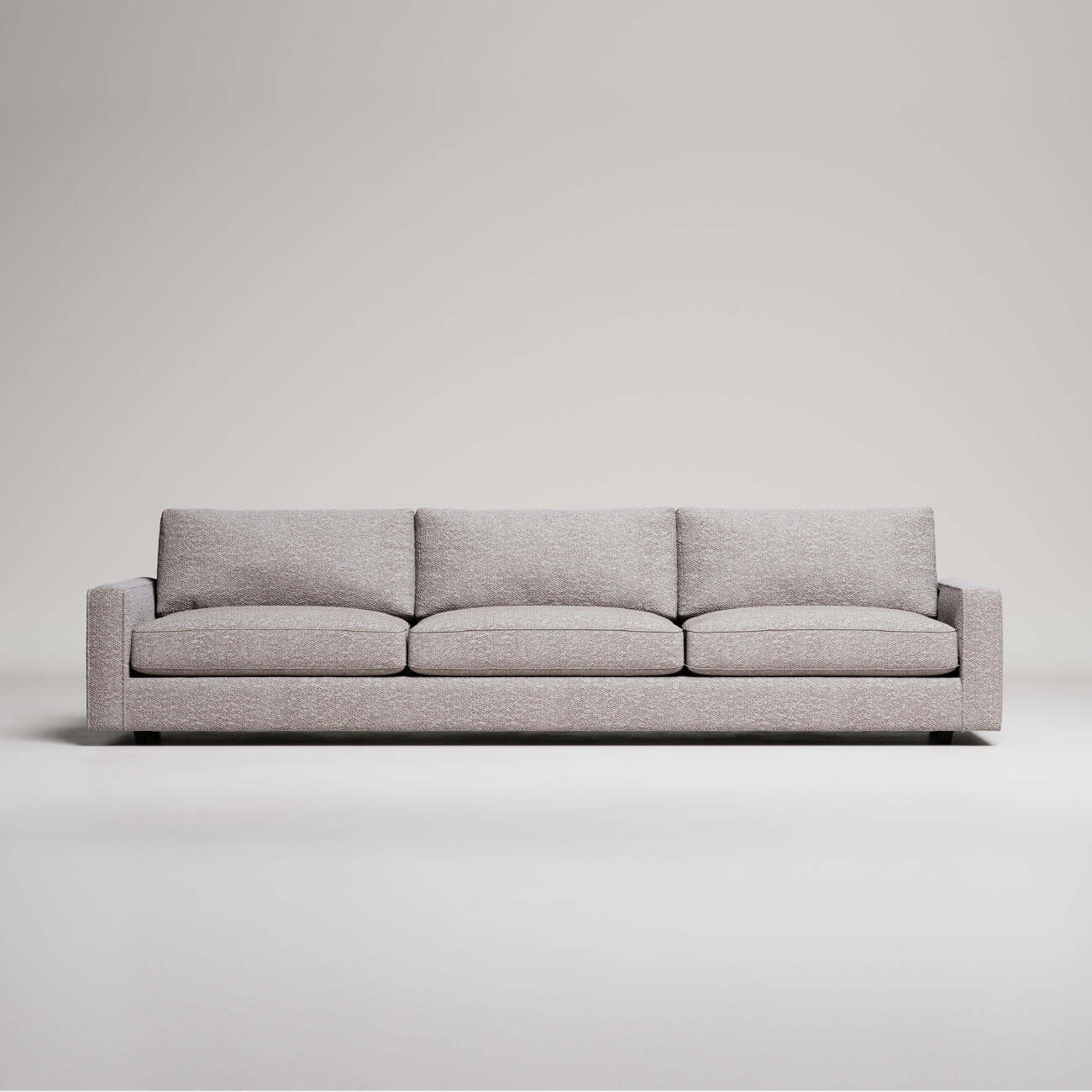 Modern three-seater sofa in light grey textured fabric with clean lines against white background