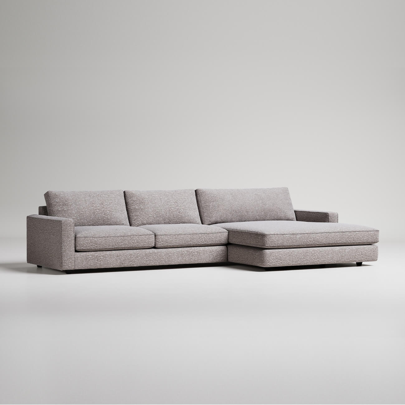 Modern grey L-shaped sectional sofa with chaise lounge on white background, minimalist furniture design