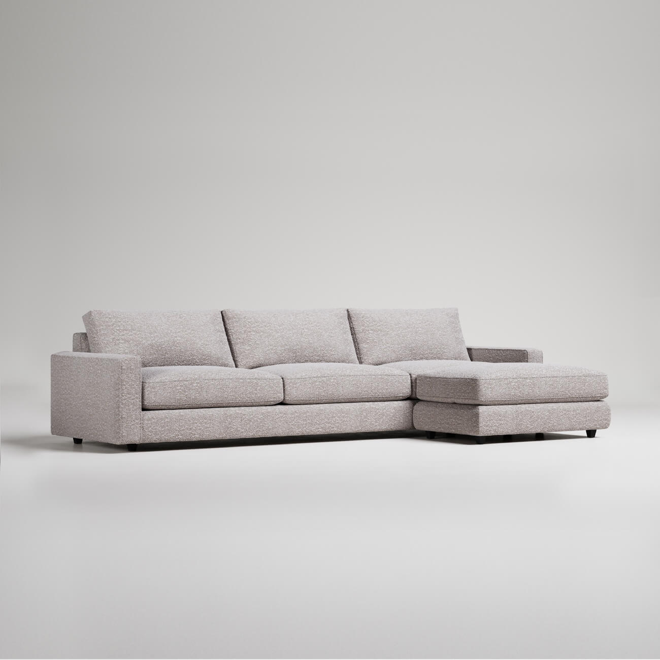 Modern L-shaped sectional sofa in light gray textured fabric with clean lines and chaise lounge extension