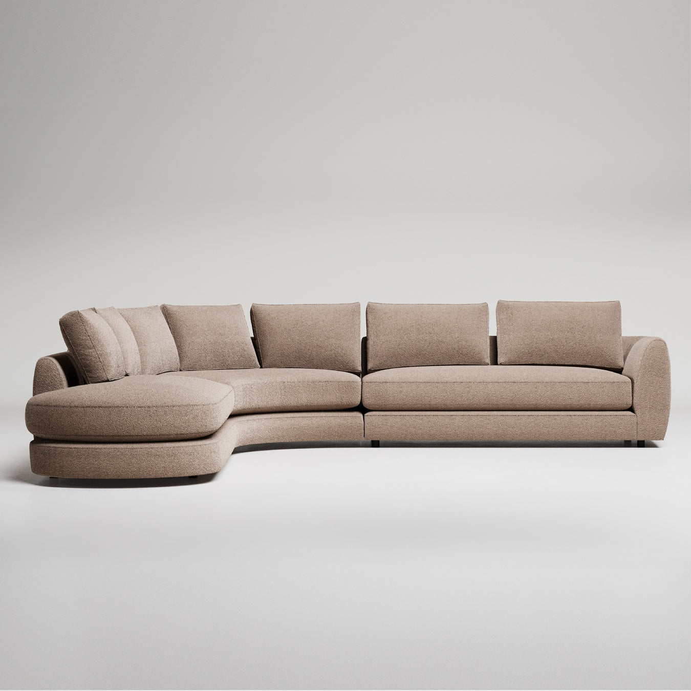 Modern camel curved sectional sofa with chaise lounge and throw pillows against grey background