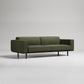 olive green sofa with wide arms and slim black legs