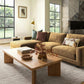 Living room with a brown sectional sofa, wooden coffee table, and decorative elements.