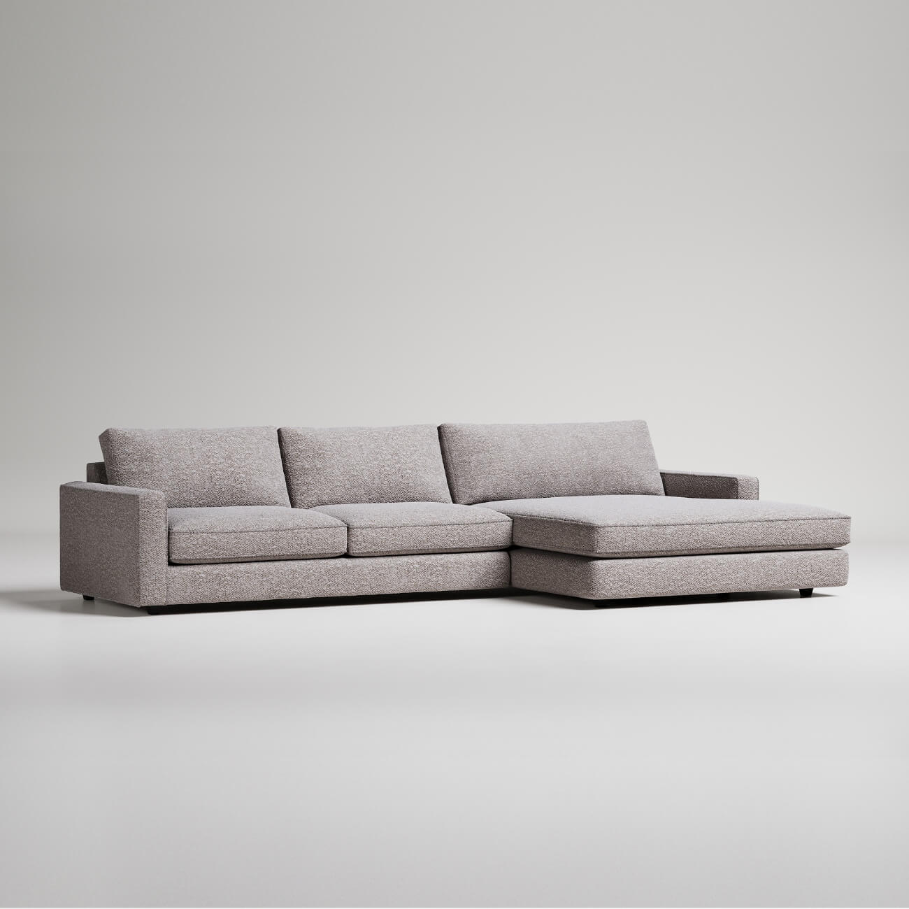 Grey sofa with two seat cushions and a large chaise
