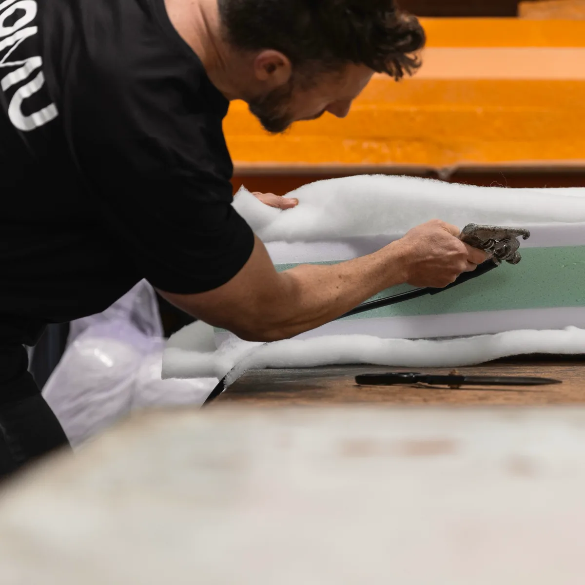 MOMU upholsterer hand-finishing a sofa cushion in our Melbourne workshop